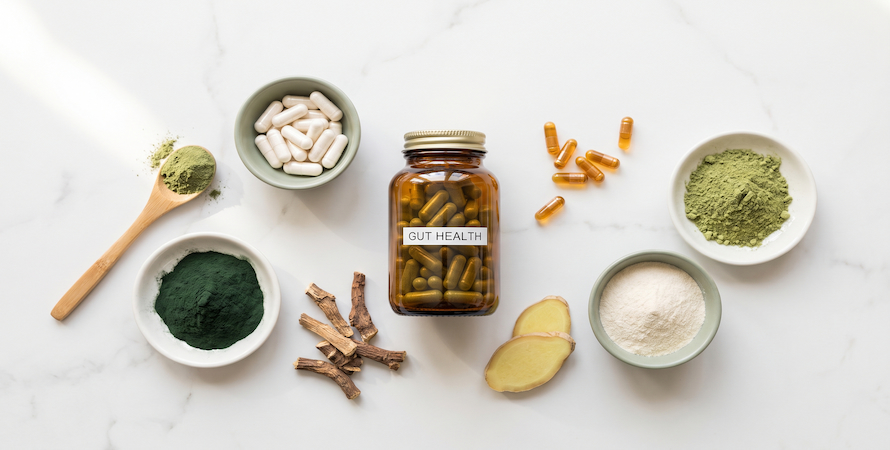 daily gut health supplements probiotics greens powder prebiotics and enzymes on white marble